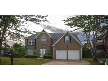 Charming two-story brick home featuring a two-car garage and well-manicured lawn at 1412 Shelnutt Ct, Hampton, GA 30228