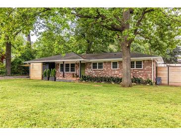 Charming brick home with a well-manicured lawn and mature trees at 991 Columbia Dr, Decatur, GA 30030