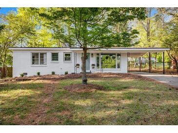 Charming white brick home with well-manicured lawn and covered front porch and driveway at 331 Zelma Sw St, Marietta, GA 30060