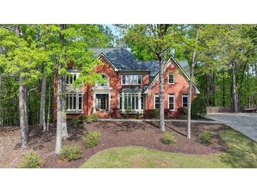Beautiful two-story brick home with a manicured lawn and mature trees providing privacy and shade at 2975 Coles Way, Atlanta, GA 30350