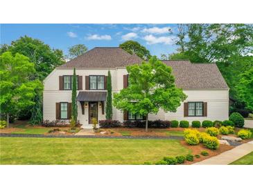 Charming two-story home with a well-manicured lawn and classic architectural details surrounded by mature trees at 3920 Cash Lndg, Marietta, GA 30066