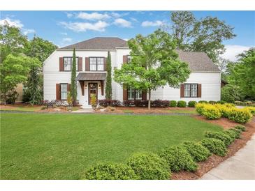 Charming two-story home featuring a well-manicured lawn, tasteful landscaping, and traditional white siding with dark shutters at 3920 Cash Lndg, Marietta, GA 30066