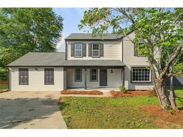 Charming two-story home featuring new siding, dark shutters, covered porch and a well-manicured front lawn at 1758 Bridgestone Ct, Marietta, GA 30066
