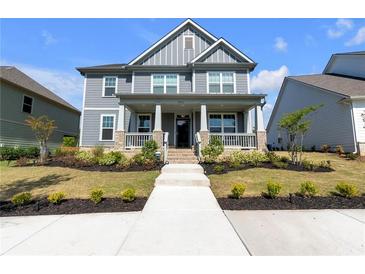 Beautiful two-story home features a welcoming front porch and well-maintained landscaping at 9913 Stretford Rd, Douglasville, GA 30135