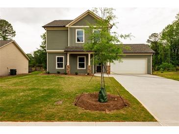 Two-story home with green siding, a well-kept lawn, covered porch, and attached two car garage at 358 Forkview Dr, Lawrenceville, GA 30044