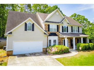 Charming two-story home with a well-manicured lawn, mature trees, and a two-car garage at 210 Creekside Overlook, Hiram, GA 30141