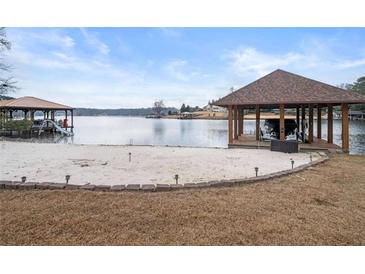 Beautiful lakefront property with a private beach, covered boat dock, and a lakeside cabana at 3167 Bay View Dr, Jonesboro, GA 30236