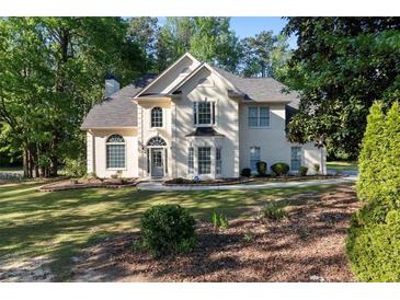 Charming two-story traditional home with a well-manicured lawn and lush landscaping at 120 Julia Ct, Fayetteville, GA 30214