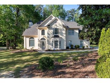 Charming traditional home with manicured front lawn and lush landscaping at 120 Julia Ct, Fayetteville, GA 30214