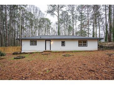Charming single-story home featuring a white exterior, black trim, and a well-manicured yard at 5101 Rockbridge Rd, Stone Mountain, GA 30088