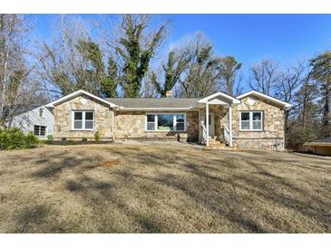 Charming single-story stone home with a well-manicured front yard, offering a cozy and inviting curb appeal at 1721 Hortense Nw Pl, Atlanta, GA 30318