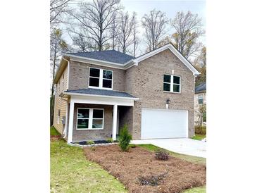 Charming two-story brick home featuring a covered porch, two-car garage, and a well-manicured front yard at 3357 Bonnes Ct, Ellenwood, GA 30294