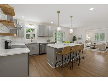 Modern kitchen boasts stainless steel appliances, a center island, and pendant lighting at 2590 Eastwood Dr, Decatur, GA 30032