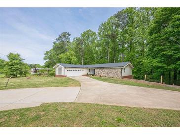 Charming ranch-style home with stone accents, attached garage, and a large front yard at 3349 Old Atlanta Rd, Suwanee, GA 30024