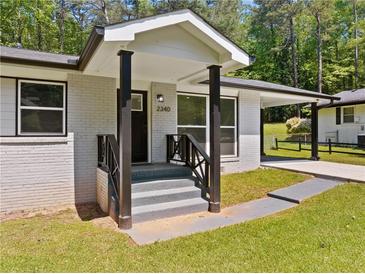Inviting front entrance with a covered porch, black railings and freshly painted brick at 2340 Cresta Dr, Decatur, GA 30032