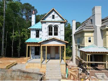 New construction home featuring a classic design, porch and second story arched windows at 11825 Serenbe Ln, Chattahoochee Hills, GA 30268