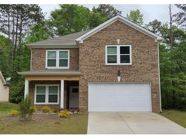 Charming brick two-story home featuring a white two-car garage and a manicured front yard at 3362 Bonnes Ct, Ellenwood, GA 30294