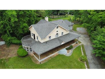 Aerial view of a large home with a wraparound porch and a circular balcony at 3884 Vic Ar Ct, Peachtree Corners, GA 30360
