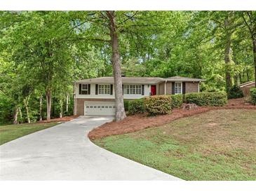 Charming home with a red front door, a two car garage, and a lush, green lawn at 2488 Fontainebleau Dr, Dunwoody, GA 30360