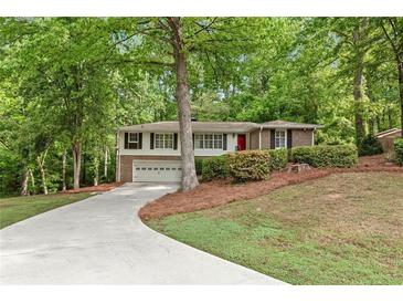 Charming split-level home with a two-car garage and long driveway, nestled among mature trees at 2488 Fontainebleau Dr, Dunwoody, GA 30360