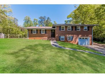 Charming single-Gathering home featuring a lush green lawn, brick facade, and attached garage at 5702 Forest Dr, Acworth, GA 30102