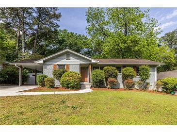 Charming single-story home featuring a well-manicured lawn, inviting curb appeal, and mature trees at 1875 Fairway Ne Cir, Atlanta, GA 30319