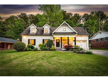 Charming white brick home featuring dormer windows and a well-manicured front yard at dusk at 917 Gaylemont Cir, Decatur, GA 30033