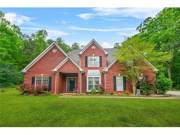 Charming two-story brick home with a well-manicured lawn and colorful flower beds at 2498 Highway 212, Covington, GA 30016