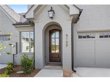 Inviting front entrance with a handsome wood door and brick facade for a touch of timeless elegance at 5128 Noble Village Way # 35, Lilburn, GA 30047