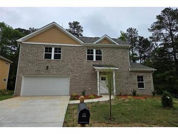 Two-story brick home featuring an attached garage and a well-manicured front lawn at 3368 Bonnes Ct, Ellenwood, GA 30294