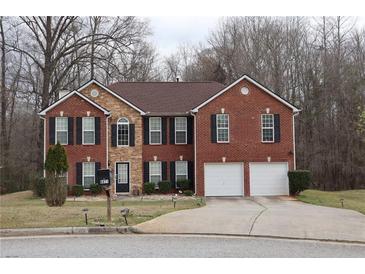 Charming brick two-story home featuring a two-car garage, manicured lawn, and classic architectural details at 8871 Jimmy Lee Cir, Jonesboro, GA 30238