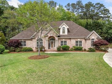 Charming brick home featuring manicured landscaping, a well-maintained lawn, and a classic architectural style at 674 Owl Creek Ct, Powder Springs, GA 30127