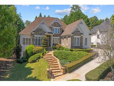 Inviting exterior of a stone and siding home featuring a manicured lawn and well-maintained landscaping at 8715 Islesworth Ct, Duluth, GA 30097