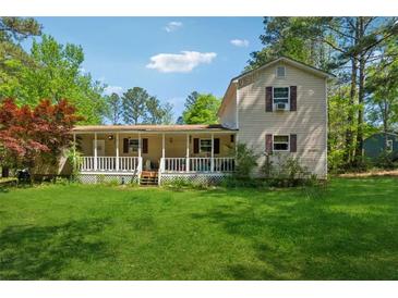 Charming two-story home with a front porch, situated on a grassy lot surrounded by mature trees at 151 Grandma Branch Rd, Grantville, GA 30220