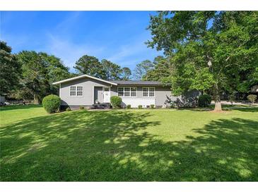 Charming single-story home with a lush green lawn and mature trees, providing a welcoming curb appeal at 205 Tamea Trl, Covington, GA 30014