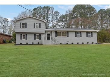 Charming split-level home featuring a well-maintained yard, gray brick, and symmetrical window design at 2017 Allwood Ct, Lawrenceville, GA 30044