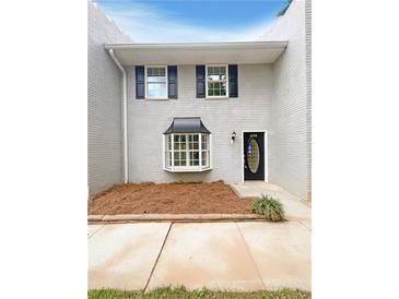 Charming two-story home with grey brick, complemented by black shutters and a manicured front yard at 1098 Eastview Ne Cir, Conyers, GA 30012