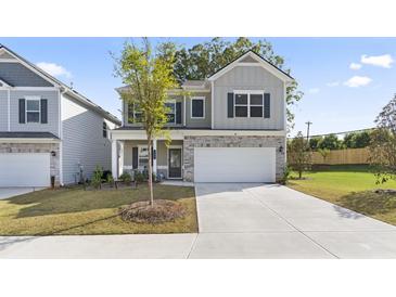 Charming two-story home featuring a two-car garage and a beautifully landscaped front yard at 305 Knights Ct, Canton, GA 30115