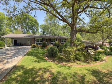Charming single-story home with mature landscaping and a covered carport at 4360 Pleasant Forest Dr, Decatur, GA 30034