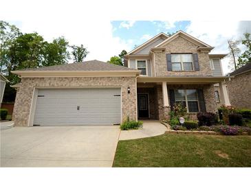 Charming two-story brick home with a well-manicured front yard and attached two car garage at 1142 Terrasol Rdg, Lilburn, GA 30047