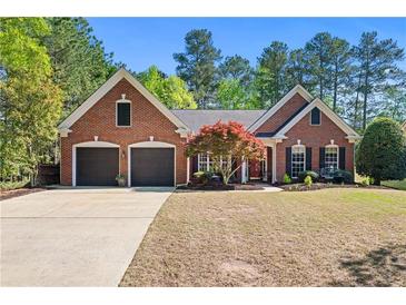 Charming brick home with a well-maintained lawn, mature landscaping, and a two-car garage at 1315 Badingham Dr, Cumming, GA 30041