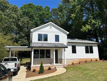 Charming two-story home with white siding, modern windows and a covered carport and manicured front yard at 169 Long Dr, Marietta, GA 30060
