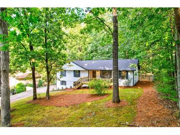 Charming white ranch-style home boasts a lovely front yard with mature trees at 2152 Tourney Dr, Marietta, GA 30062