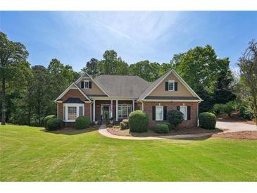 Charming single-story brick home with lush green lawn and manicured landscaping on a sunny day at 5030 Princeton Trce, Cumming, GA 30041