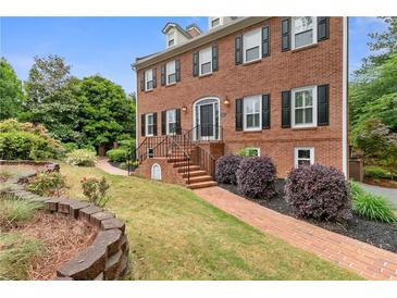 Charming brick home with manicured lawn and lush landscaping at 100 Barnard Pl, Atlanta, GA 30328