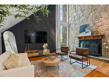 Cozy living room showcasing a stone fireplace, stylish seating, and modern design elements at 5159 Sw East Shore Sw Dr, Conyers, GA 30094