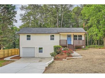 Charming two-story home features a welcoming blue door and a well-maintained front yard with garden at 1213 Anderson Mill Rd, Austell, GA 30106