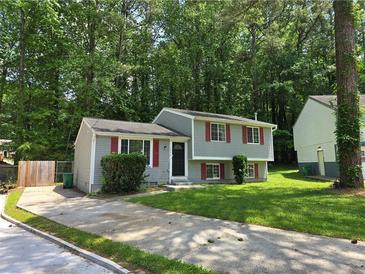 Charming two-story home with gray siding, red shutters, and a well-maintained lawn in a lush, green neighborhood at 2036 Countydown Ln, Stone Mountain, GA 30088