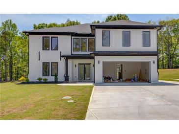 Stunning new construction modern home with a white exterior, black trim, and an attached two-car garage at 51 Deer Canyon Dr, Auburn, GA 30011