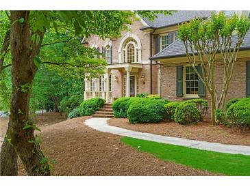 Stately brick home with manicured landscaping and inviting front entrance at 1100 Kensington Ct, Johns Creek, GA 30022